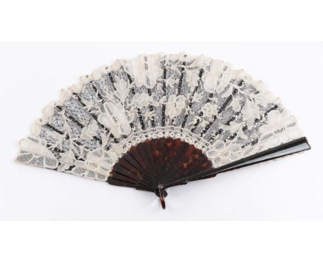 A Tortoiseshell Fan, circa 1900, mounted with a leaf of black net, applied white Brussels Bobbin lace, and tiny silver sequin