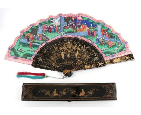 A Boxed Chinese Mandarin Fan, Qing Dynasty, the monture of wood lacquered in black and gold. The upper guards show two figure