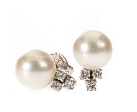 PAIR OF PEARL AND DIAMOND STUD EARRINGS, each set with a spherical pearl 8.6mm in diameter, flanked by three round brilliant 