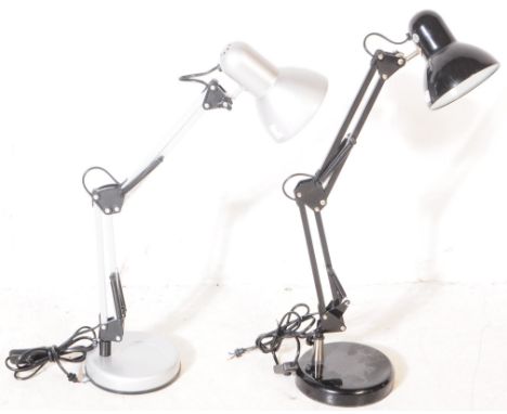 Two contemporary anglepoise lamps in black and silver colourways. Having circular bases with spring loaded arm supports with 