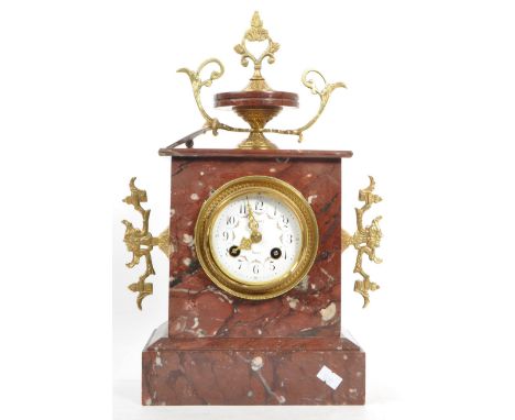 A 19th century red marble mantel clock. The clock having ornate pierced ormolu mounted fixtures to finial and sides. The face