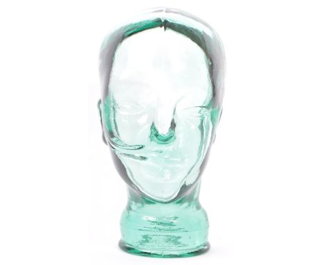 A vintage 20th century clear green glass millinery mannequin pressed glass head having moulded features on a circular base. M