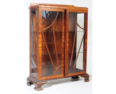 An early 20th century circa 1930s Art Deco era walnut display cabinet. The cabinet having low gallery back over twin doors, e