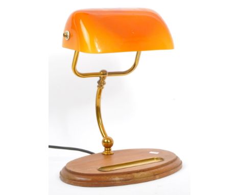 A vintage 20th century circa 1960s desk top bankers lamp having amber glass shade and being raised on gilt arm over an oval o