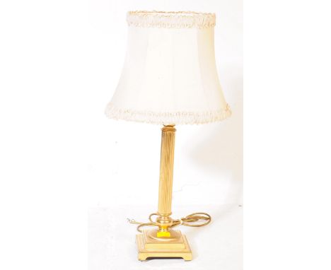 A 20th century vintage brass table lamp of columnar form having reeded shaft over stylobate base, accompanied by white shade 
