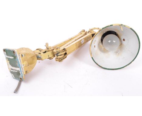 A mid 20th century retro industrial factory warehouse clamp lamp. Having a conical shade with three hinge joints on the bar s
