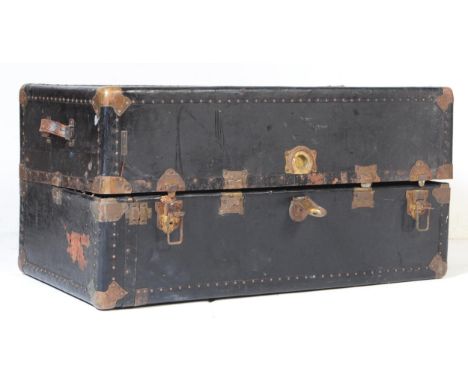 A vintage 20th century railway travel trunk suitcase. Of rectangular form with brass bound and stud work. Twin leather carry 