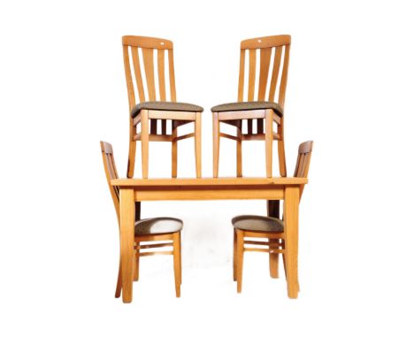 A contemporary oak furniture land style dining table and four chairs. With a rectangular plank top with square upright suppor