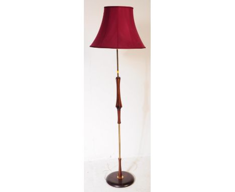 A mid 20th century teak and brass standard floor standing lamp having bentwood type spindles to centre over a circular footed