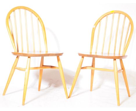 A pair of retro 20th century Ercol beech and elm windsor 139 dining chairs. Each having a spindle back rest above saddle seat