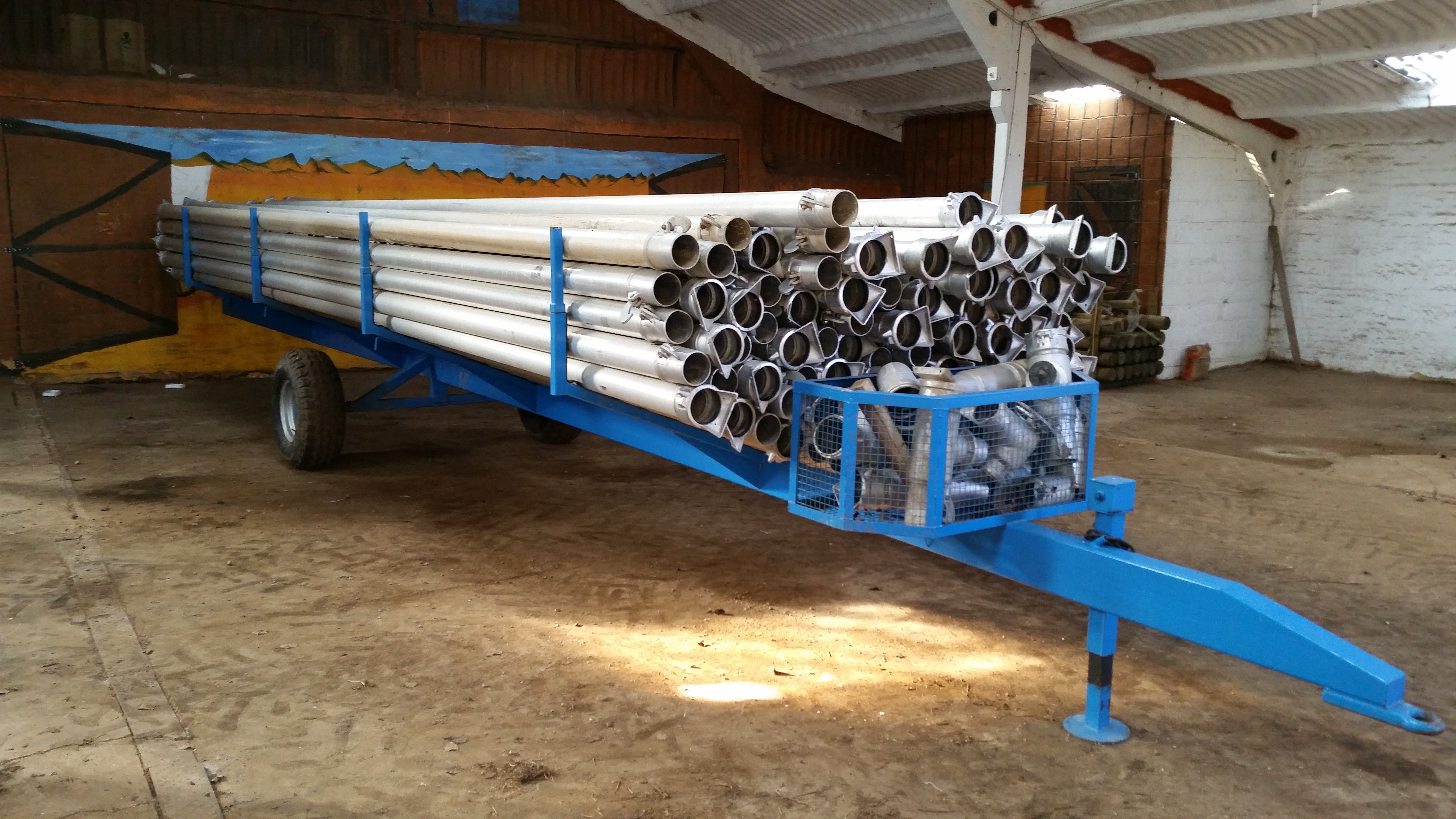 Irrigation pipe trailer with quantity of pipes and fittings. The