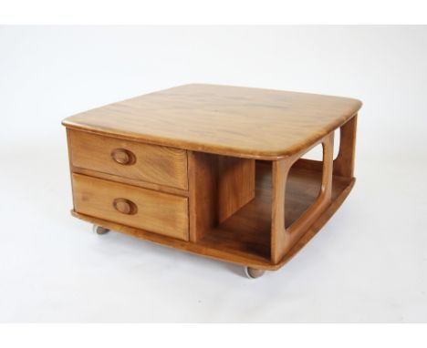 An Ercol 'Pandora' light elm coffee table, the two tier square table with two drawers, raised upon shepherd castors, 40cm H x