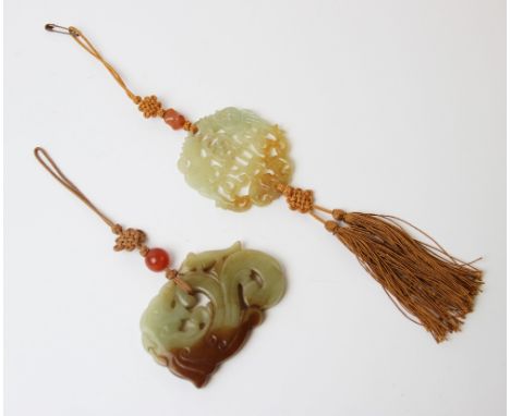 A Chinese green and mutton fat jade carving, depicting a dragon carp, 7cm wide, suspended from a tassel, with a further carve