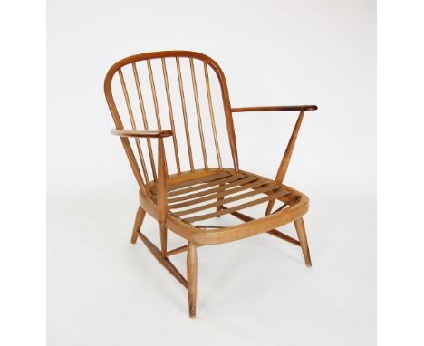 A mid 20th century Ercol light beech wood open armchair, the stick back extending to out swept arms, raised upon tapering sho