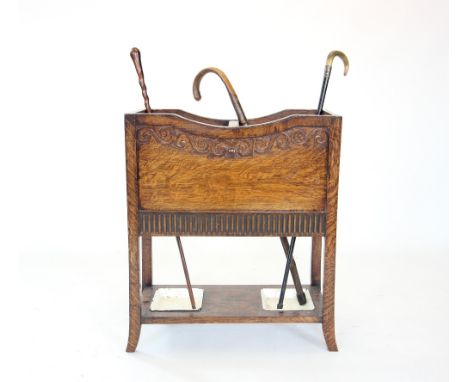 An early 20th century oak stick stand, with twin compartments over a pair of inset metal trays, 72cm high, along with three a