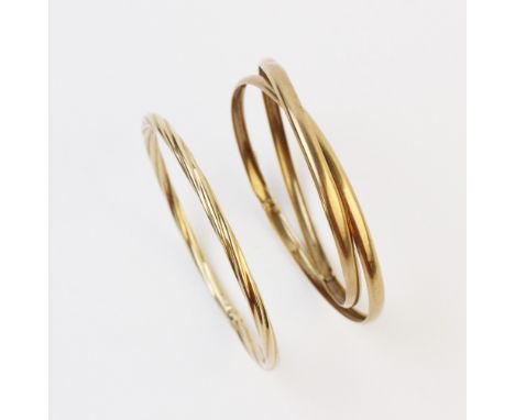 A 9ct gold slave bangle, the yellow gold twisted design bangle measuring 7.4cm diameter, together with a pair of 9ct gold int