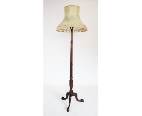 A George III style mahogany standard lamp, 20th century, the ring turned gun barrel column raised upon three down swept cabri