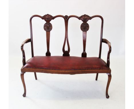 An early 20th century Chippendale revival twin seat mahogany chair, with two carved shell crests above tapering and cross ban