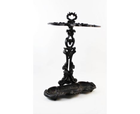 A Victorian style cast iron stick stand, stamped C G F, with 'C' scroll framed twin compartments above a conforming lower tra