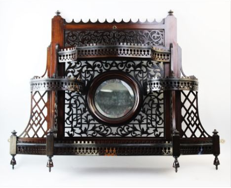 An early 20th century Chinese Chippendale revival mahogany wall shelf, of fretwork form, the central circular bevelled mirror