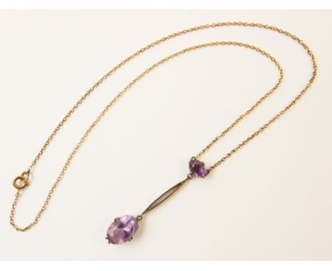 An early 20th century amethyst set drop pendant, comprising an oval mixed cut amethyst measuring 7mm x 5mm, suspending a larg