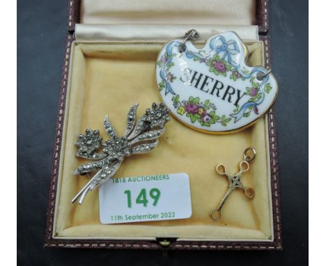 A 9ct gold cross pendant of decorative form, approx 1.7g with a ceramic sherry decanter label and a marcasite white metal flo