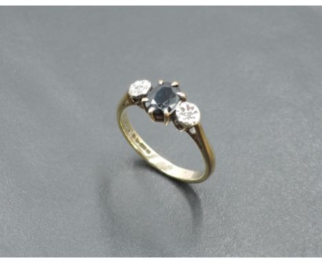 An oval sapphire ring flanked by two diamond chips in illusionary mounts on a 9ct gold loop, size K &amp; approx 2g