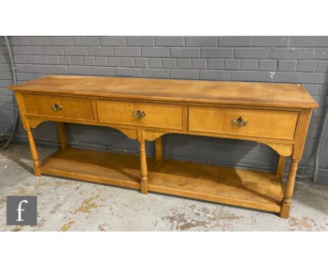 A contemporary light oak dresser in the 17th Century style by Dennis Tomlinson of Stratford-On-Avon, the moulded edge top ove