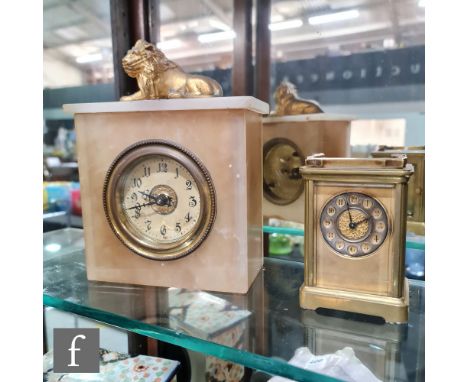 An early 20th Century alabaster mantle clock surmounted with a recumbent gilt lion, Arabic dial, height 28cm, and similar Fre