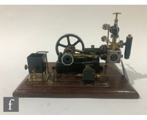 A Stuart single cylinder horizontal engine, with water tank and six spoked flywheel, raised to a wooden base, height 16cm, wi