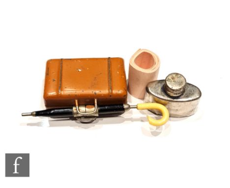 An early 20th Century novelty travelling inkwell in the form of a tinned brown painted trunk fastened by a brolly which separ