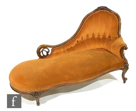A Victorian carved and pierced mahogany button back chaise longue on cabriole legs, upholstered in pale tangerine plush, leng