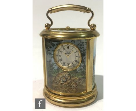 A Halcyon Days Enamels carriage clock of oval form, the dial, top and three panels detailed with scenes of tigers and other b