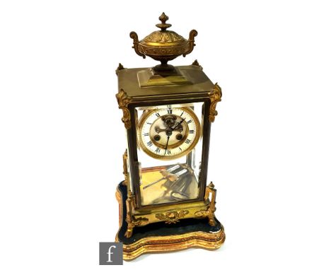 A late 19th Century French gilt metal and bevelled glass regulator mantel clock, the case surmounted by a twin handled urn wi