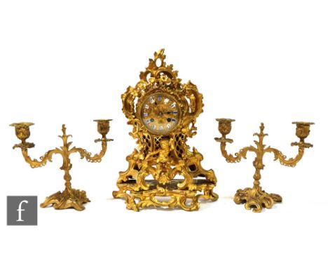 A 19th Century French gilt mantle clock with eight day striking movement, enamelled numeral dial below a garland of flowers a