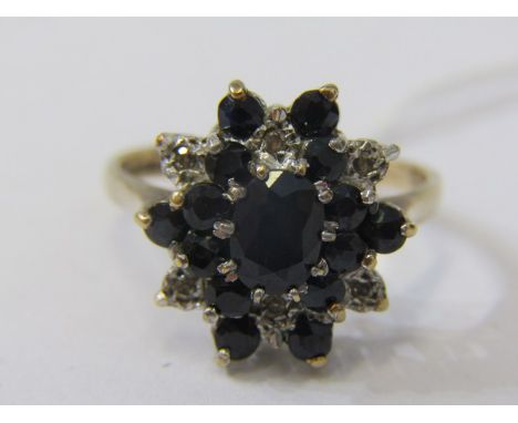 9CT YELLOW GOLD SAPPHIRE AND DIAMOND CLUSTER RING, principal oval cut sapphire surrounded by accent brilliant cut diamonds an