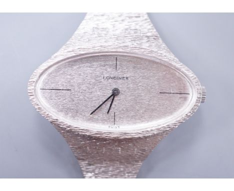 A lady's 1970's silver Longines manual wind wrist watch, with oval dial, on a textured silver bracelet.**CONDITION REPORT**PL