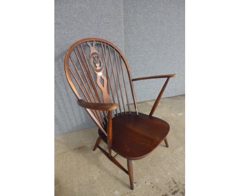 An Ercol Golden Dawn elm and beech fleur de lys armchair 
