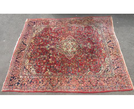 A large early 20th century wool Persian style carpet, having large central field in 'garden' type design, predominantly red/b