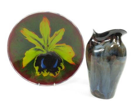 A Poole pottery plate decorated with an iris, 26.5cm diameter, along with a Gwenny pottery vase 21cm high