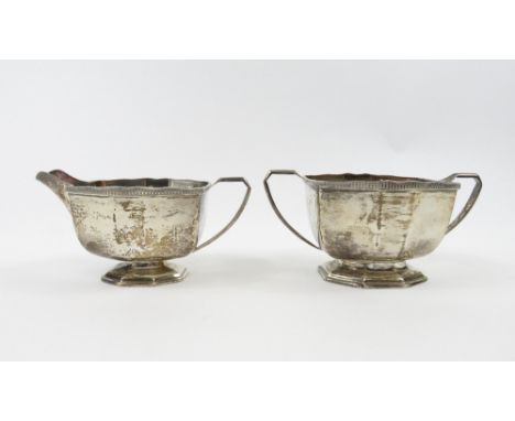 A silver cream jug and matching sugar basin by George Wish &amp; Co Ltd, Sheffield 1933, of panelled rectangular outline, wit