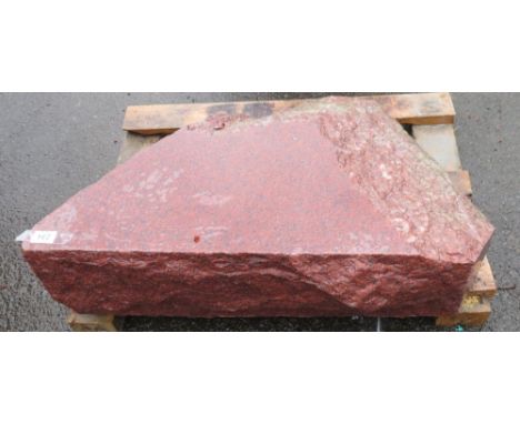 A pink granite boulder with polished surface
