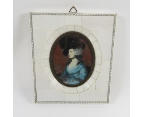 An early 20th century miniature portrait of seated lady, wearing a black hat and blue dress in a veneered ivory frame