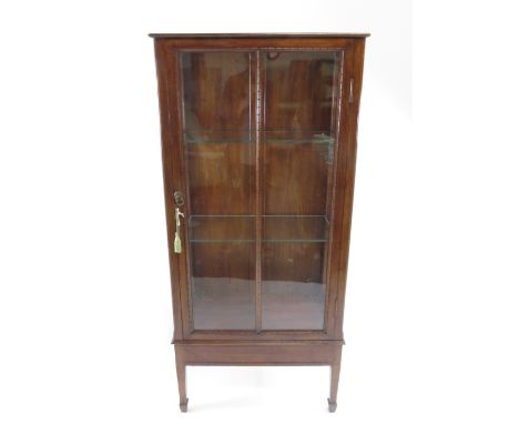 A 20th century walnut display cabinet, with two adjustable glass shelves, on tapering legs, 154cm high, 66cm long, 30cm deep