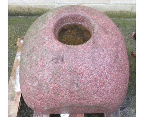 A large pink granite smooth boulder plant holder