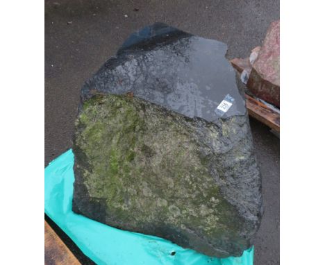 A dark granite boulder with polished surface
