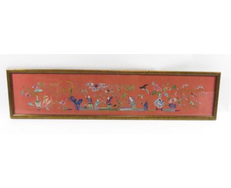 A Chinese silk embroidered panel, worked in coloured silks with boys playing amongst trees and with birds and butterfly, on a