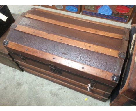 A domed top wooden bound travelling trunk with removable shelf 