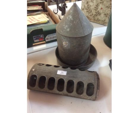 A galvanised chicken drinker and chick feeding trough