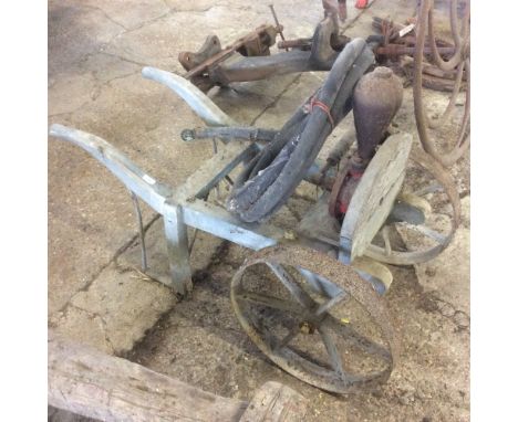 A small wooden two wheel trolley fitted with manual water pump and hose 
